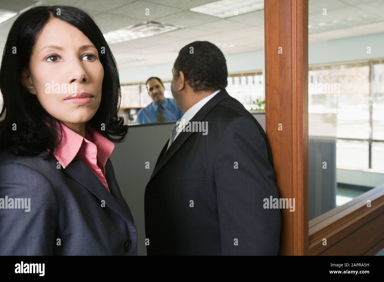 Eine Geschäftsfrau mit zwei Geschäftsmänner stehend in einem Büro in Nahaufnahme Stockfoto