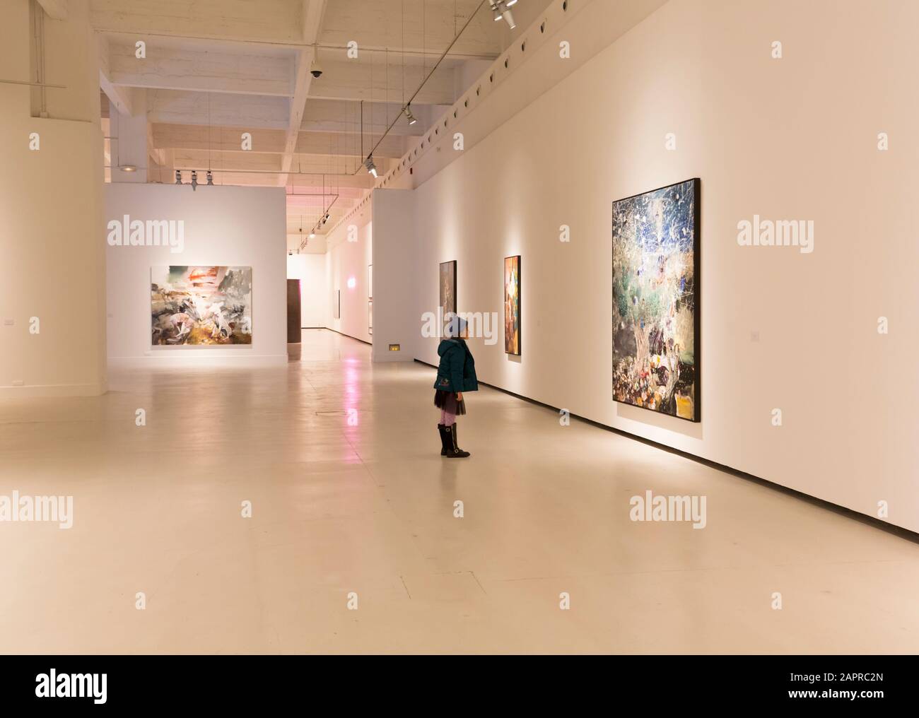 Kleines Mädchen, das während einer Ausstellung seines Werks im Centro de Arte Contemporáneo, Málaga, Provinz Málaga, Costa ein Gemälde von Adrian Ghenie betrachtet Stockfoto