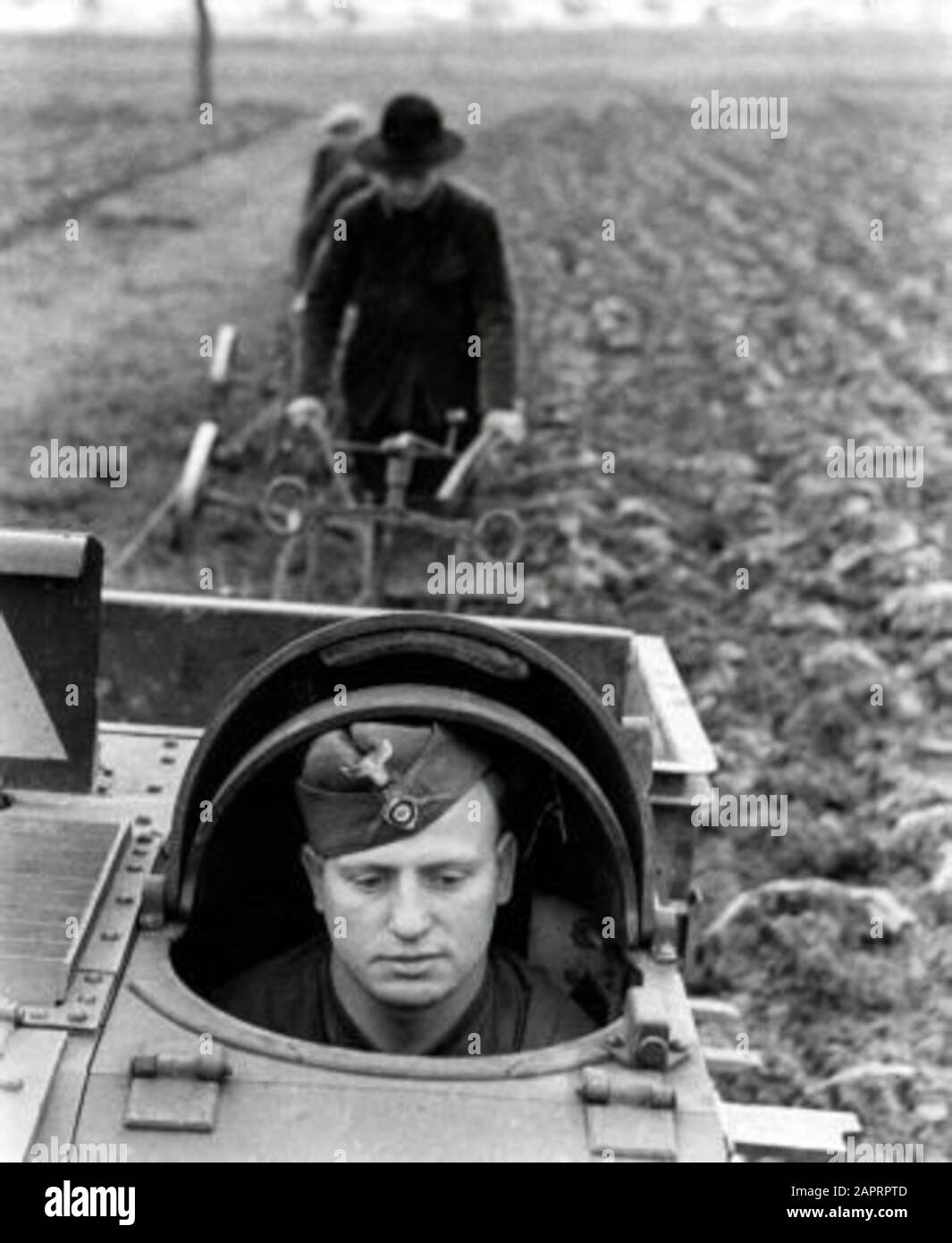 Spaarnestad Foto/SFA02804386 Zweiter Weltkrieg Deutscher Soldat im Panzerkuppel der Tankette. Die hinter ihnen stehenden französischen Bauern bekommen Hilfe von deutschen Soldaten beim Pflügen des Landes. Frankreich, 1941. [Möglicherweise ein Renault UE aus Frankreich: Ein gepanzerter Traktor, von den Deutschen modifiziert und benutzt]. Zweiter Weltkrieg. Deutscher Soldat in einem Panzer. [Möglich ein Renault UE, ein französisches Fahrzeug für armorierte Traktoren oder Infanteriezulieferer, entwickelt für Versorgungsarbeiten, die von den Deutschen verwendet und modifiziert werden]. Deutsche Soldaten helfen den französischen Bauern, ihre Felder zu pflügen. Frankreich, 1941; Stockfoto