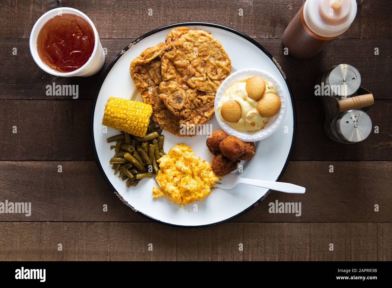 Schweinekotelteller und süßer Tee auf einem rustikalen Holztisch Stockfoto