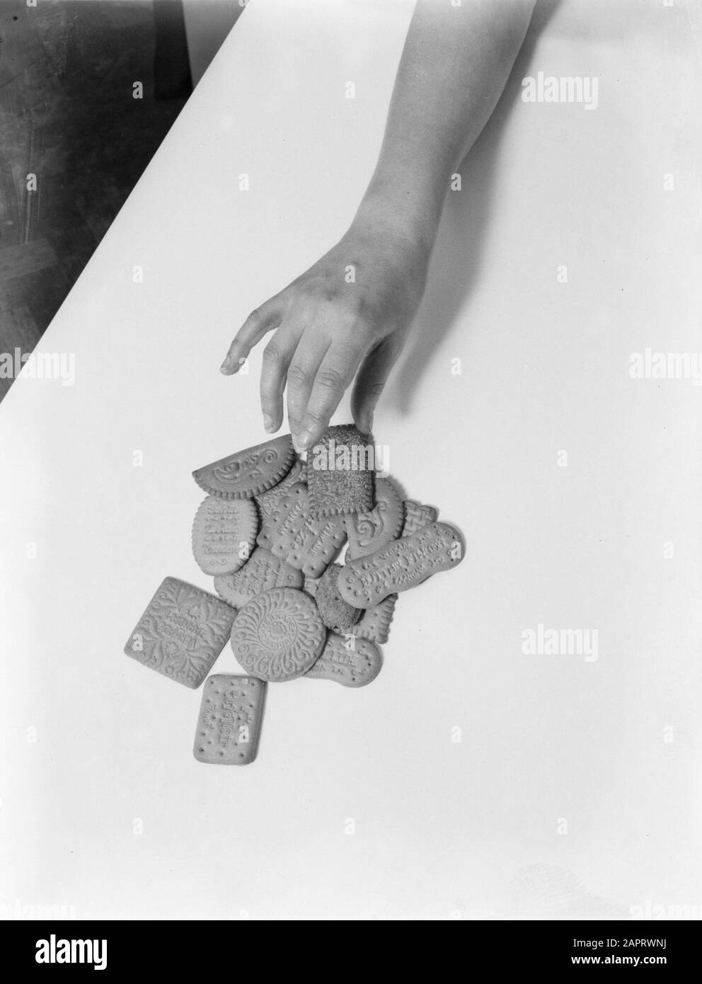 Werbefotografie EINE Hand wählt einen Keks Verkade Datum: 1932 Schlagwörter: Hände, Kuchen Institutionenname: Verkade Stockfoto