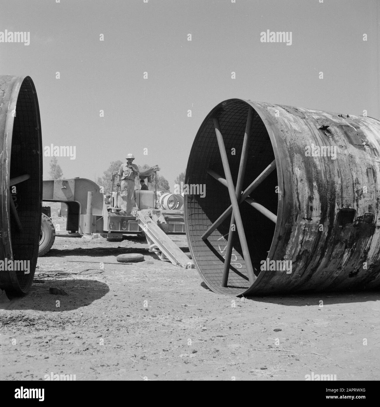 Ein intern ausfahrendes Rohr, das aus einem Lastwagen entrollt wurde und in einem Bewässerungsprojekt in der Negev-Wüste verwendet wird Datum: 1. Januar 1960 Standort: Israel, Negev Schlüsselwörter: Bewässerungsarbeiten, Rohre, Streben Stockfoto