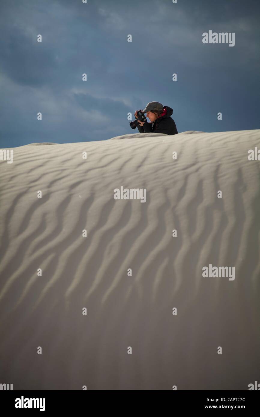 Fotografin macht ein Bild mit weißem Sand im Vordergrund, White Sands National Monument; Alamogordo, New Mexico, USA Stockfoto