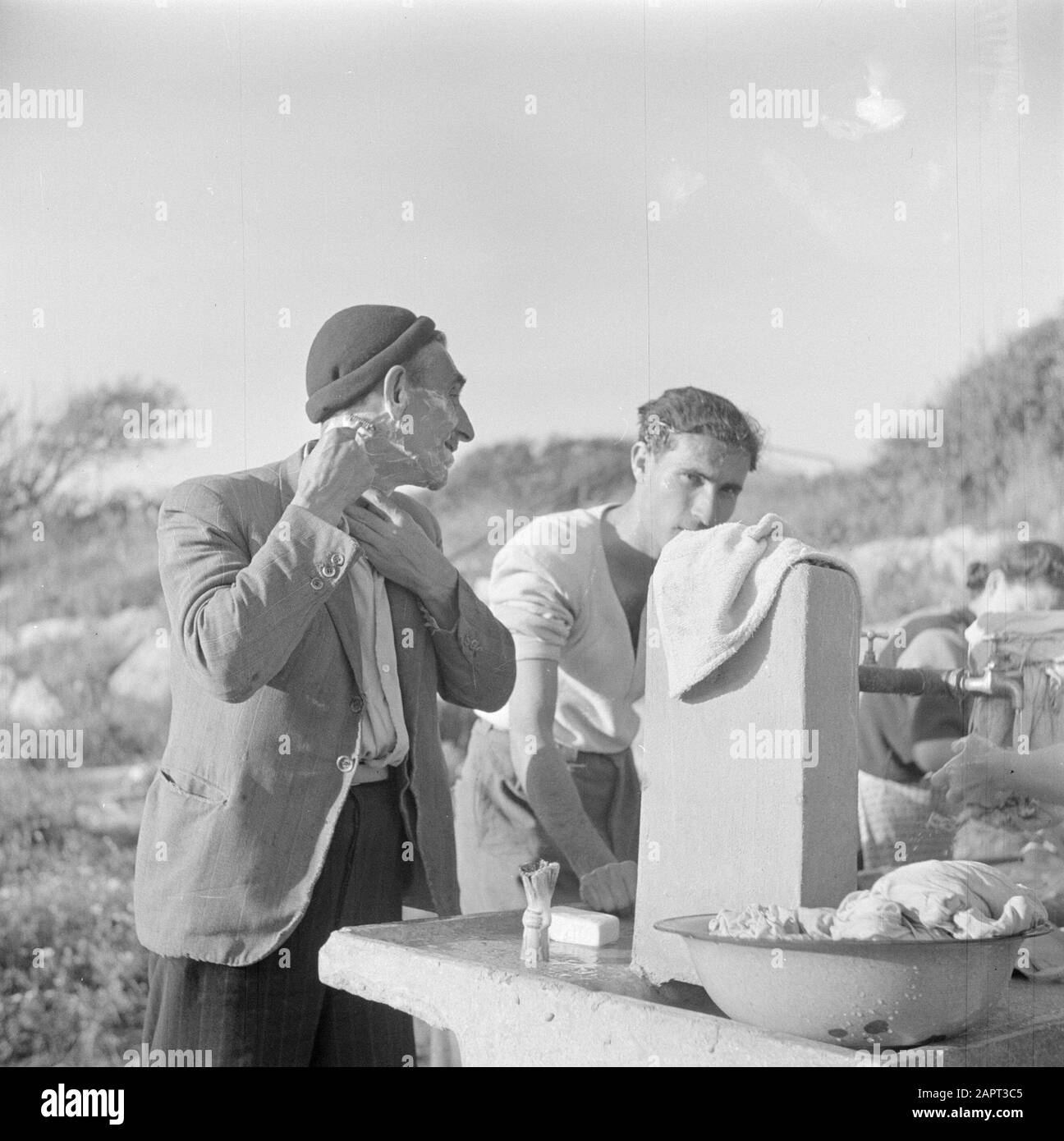 Israel 1948-1949 Auswanderer (Öl) im Durchgangslager St. Lucas in Haifa während der Rasur am Waschplatz im Freien Datum: 1948 Ort: Haifa, Israel Schlagwörter: Auswanderer, Lager, Körperpflegeeinrichtung Name: Saint Lucas Stockfoto