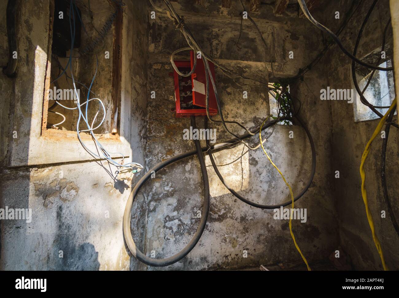 DIU, Indien - Dezember 2018: Elektrische Drähte und Kabel in einer kleinen, alten Kabine mit elektrischen Einheiten zur Übertragung von Elektrizität innerhalb des Diu Forts. Stockfoto