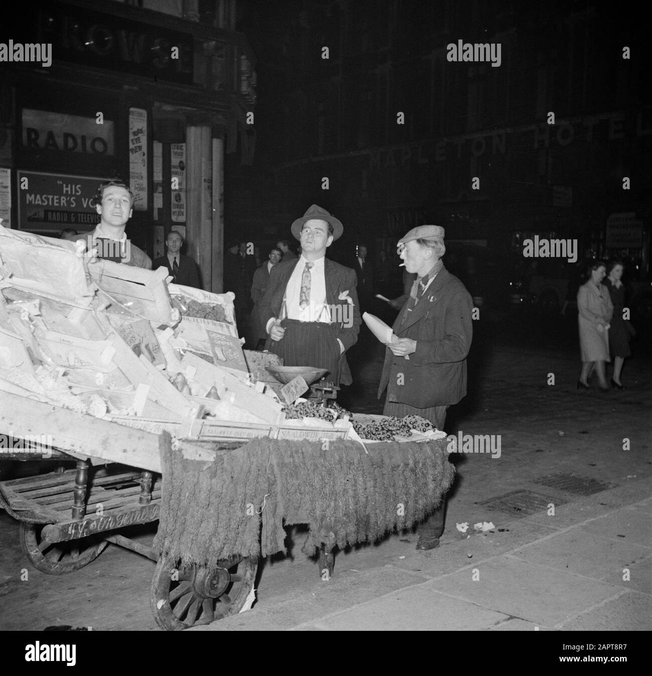 Spivs in Soho, London Fruit Sales on the Street Annotation: Spiv ist das englische Wort für "Heiler", "Schacheraar". Willem van de Poll erwähnt auf der Katalogkarte: "Die Obsthändler sind auch in der Regel Spivs" Datum: 1947 Standort: England, London Schlüsselwörter: Obst, Märkte, Schwarzhandel Stockfoto