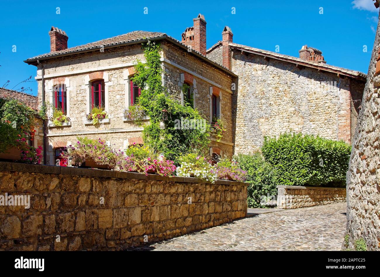 Straßenszene, Kopfsteinpflaster, alte Steingebäude, rote Fensterbesatz, Topfblumen, grüne Rebe, Textur, Perouges, Frankreich, Sommer; horizontal Stockfoto