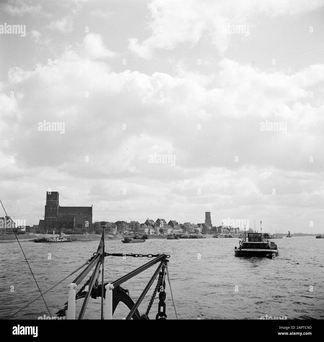 Rijnvaart, Bericht von Schlepper Damco 9: Westdeutschland Blick auf Emmerich mit am Kai angedockten Lastkähnen Anmerkung: Im Hintergrund der St. Martini-Münsterkirche und der Aldegundiskirche Datum: 1. April 1955 Standort: Deutschland, Emmerich, Westdeutschland Schlagwörter: Lastkähne, Kirchenbauten, Flüsse, Stadtbilder, Dampfschiffe Stockfoto