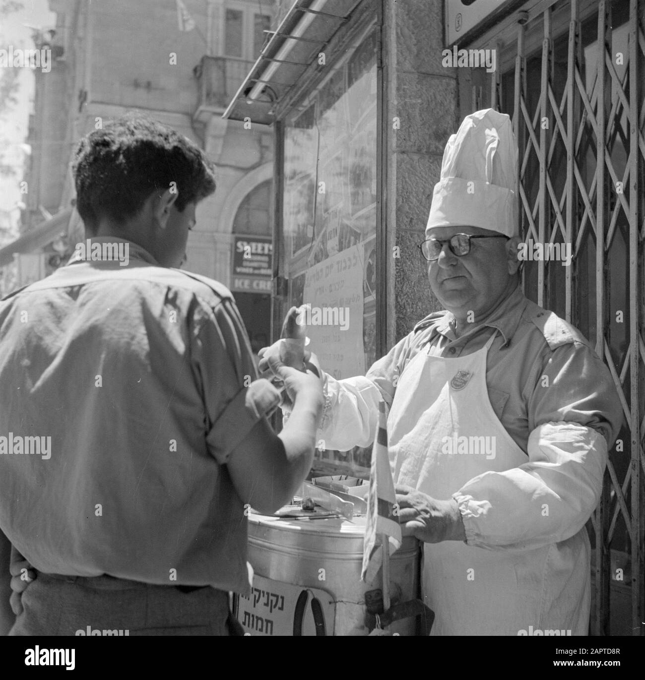 Israel 1948-1949: Jerusalem Emigrierte ehemalige deutsche Opernsängerin in seinem neuen Beruf: Straßenhändler Datum: 1948 Standort: Israel, Jerusalem, Mea Shearim Schlüsselwörter: Handel, Kopfbedeckung, Kunden, Straßenhändler, Sänger Stockfoto