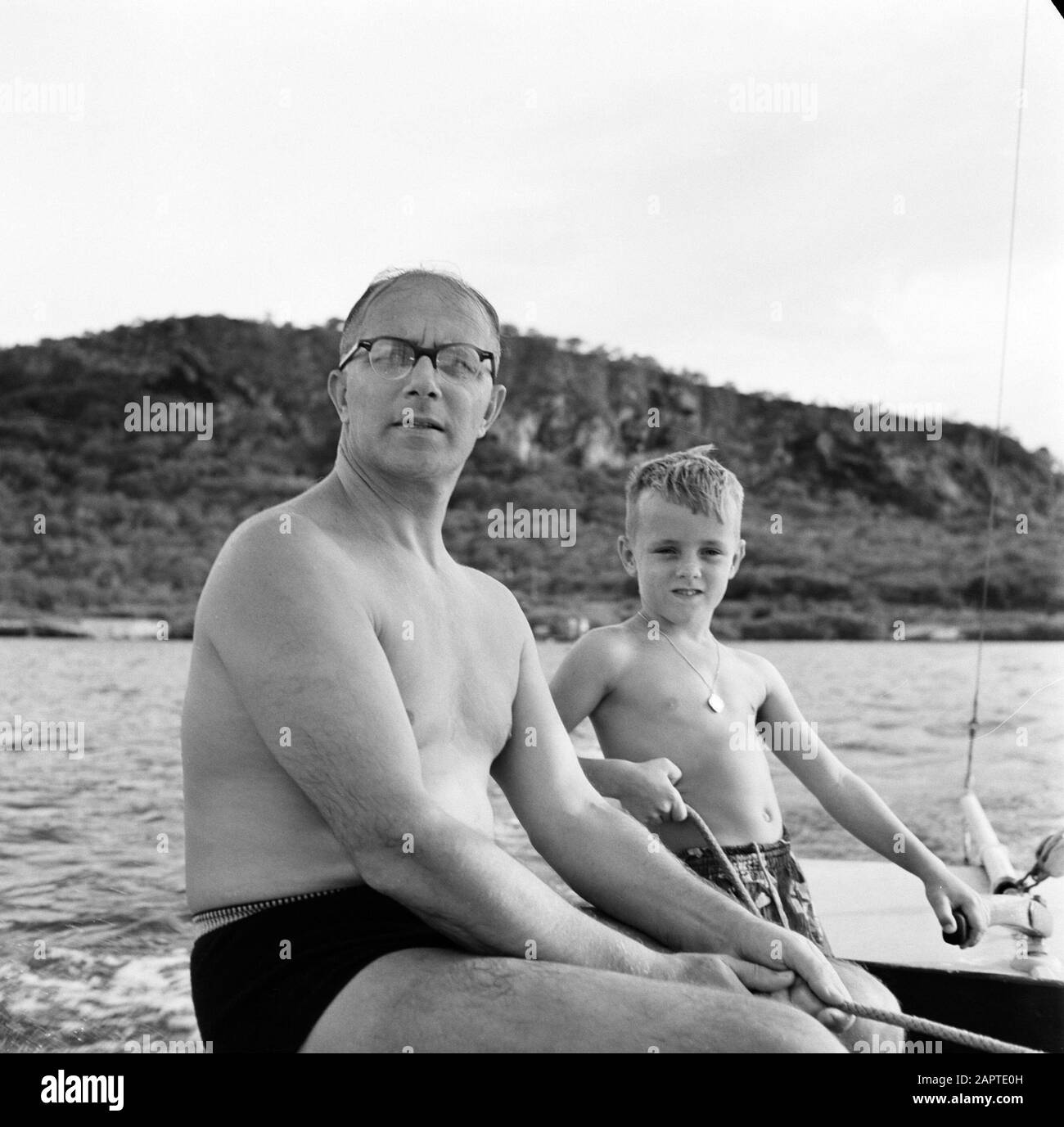 Niederländische Antillen und Suriname zum Zeitpunkt des königlichen Besuchs von Königin Juliana und Prinz Bernhard im Jahr 1955 Gouverneur Struycken und Sohn Huib auf einem segelboot Datum: Oktober 1955 Ort: Curaçao, niederländische Antillen Schlüsselwörter: Kinder, Seen, Segelschiffe Personenname: Struycken, A.A.M., Struycken, Huib Stockfoto