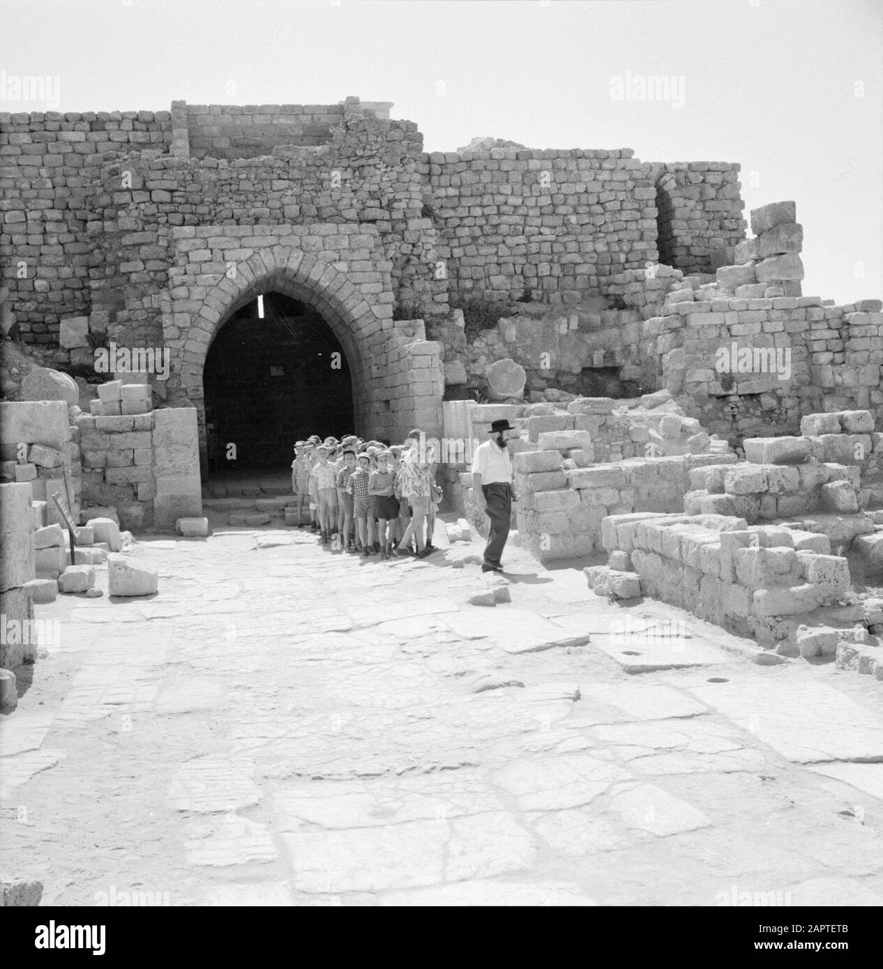 Israel 1964-1965: Caesarea, Archäologische Gruppe von Kindern, die die Gebäude von Caesarea Annotation betrachten: Caesarea ist ein Dorf und ein archäologischer Park in Israel, der im Distrikt Haifa liegt. Sie liegt etwa zwischen Tel Aviv und Haifa im Mittelmeer. Im Hinblick auf die Antike wird sie auch Caesarea Maritima genannt. Bei Caesarea wurden seit Jahrzehnten Ausgrabungen durchgeführt, und es gibt viel zu sehen. Es ist eine Touristenattraktion Datum: 1964 Ort: Caesarea, Israel Schlüsselwörter: Gebäude, Kinder, Touristen Stockfoto