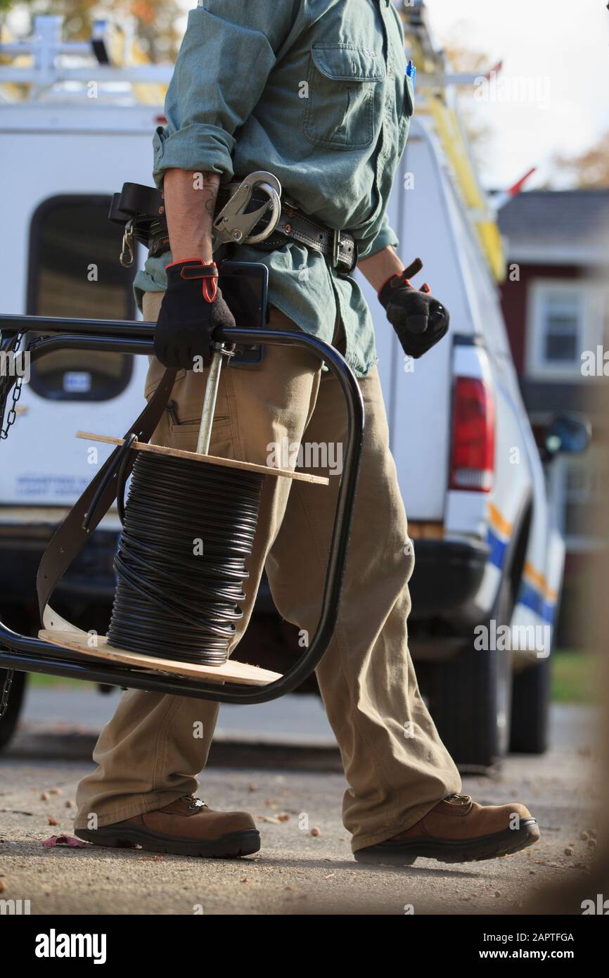 Handwerker hält Kabel für Internet-Installation mit Arbeit LKW hinter Er Stockfoto