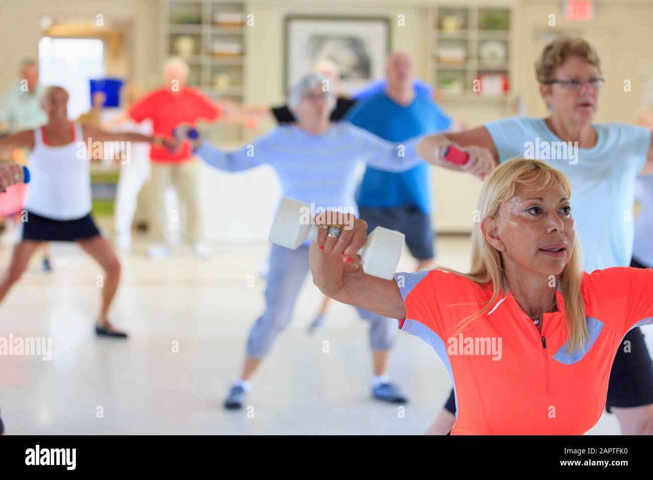 Weibliche Ausbilderin, die einen Fitnesskurs für Senioren leitet Stockfoto
