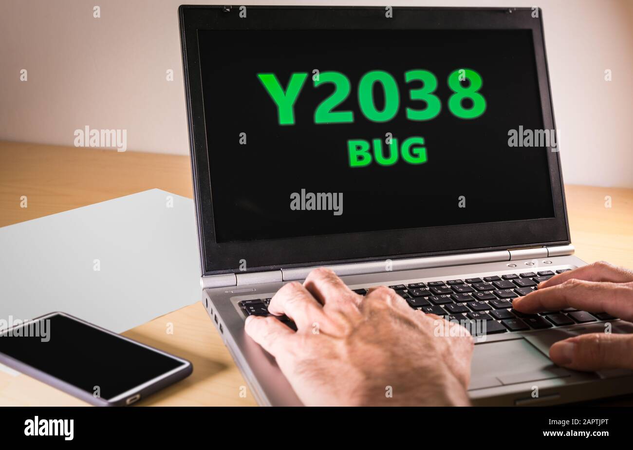 Man übergibt sich die Eingabe auf einem Laptop in Textcode. Problemkonzept Jahr 2038 Stockfoto