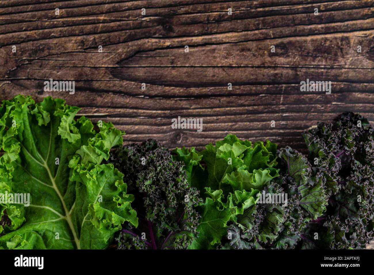 Grünes, belaubtes kaltes Gemüse isoliert auf Holztischhintergrund Stockfoto