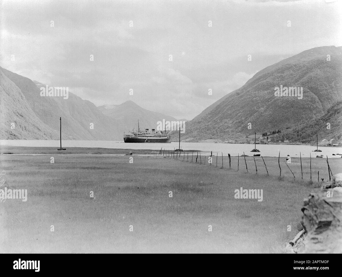 Seereise mit Frau Johan van Oldenbarnevelt nach Norwegen Das Schiff im Fjaerland-Fjord vom festen Ufer aus gesehen Datum: 1933 Ort: Norwegen, fjaerland-fjord Schlüsselwörter: Berge, Kreuzfahrten, Kreuzfahrtschiffe, Fjorde, Zäune, Hügel, Landschaften, Schiffe, Tourismus Stockfoto