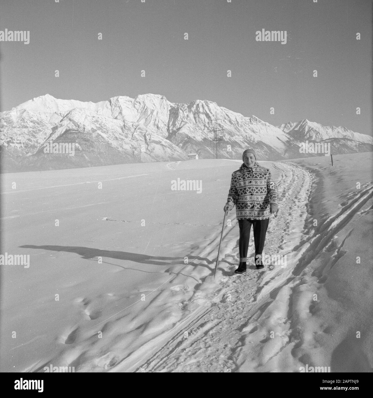 Winter in Tyrol Hilde Eschen geht im Schnee mit im Hintergrund die Karwendelberge Datum: Januar 1960 Standort: Österreich, Sistrans, Tyrol Schlüsselwörter: Berge, Landschaften, Schnee, Urlaub, Wandern, Winter persönlicher Name: Echen, Hilde Stockfoto