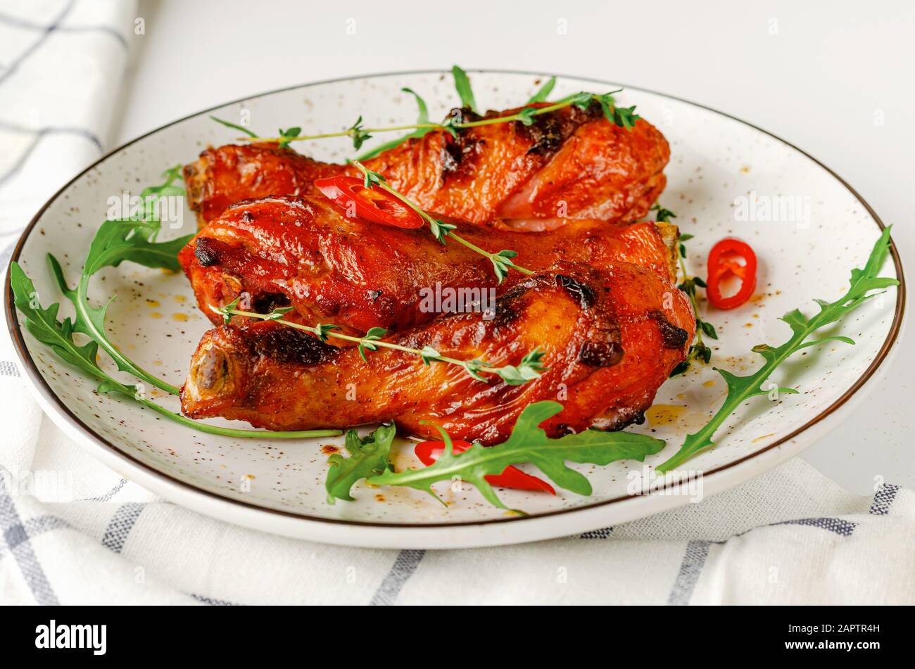 Gebraten würzige Hähnchenkeulen oder Drumsticks auf einem weißen Teller. Köstliche Mittag- oder Abendessen. Stockfoto