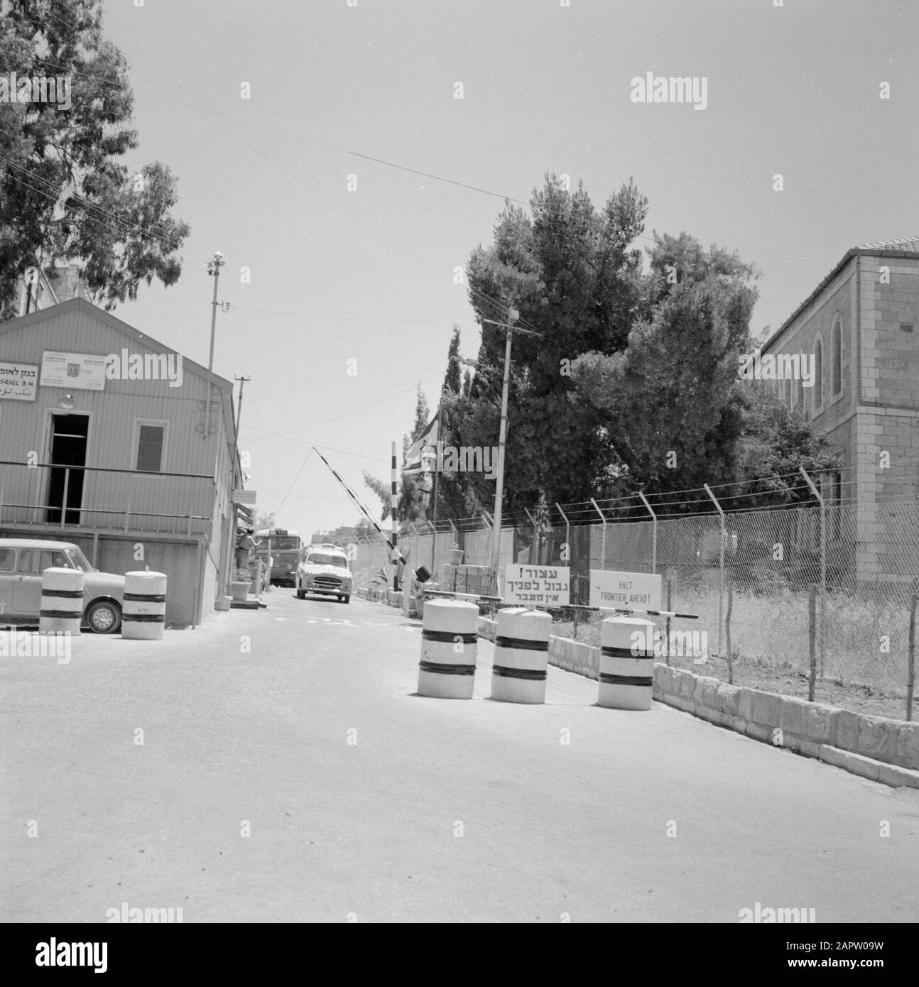 Israel 1964-1965: Jerusalem (Jerusalem), Mandelbaum Tor Jerusalem. Ein Auto fährt in Mandelbaumpoort mit einem Bus dahinter Annotation: Mandelbaum Gate ist ein ehemaliger Kontrollpunkt zwischen israelischen und jordanischen Gebieten von Jerusalem Datum: 1964 Ort: Israel, Jerusalem, Mandelbaum Schlüsselwörter: Autos, Busse, Grenzübergänge, Sprecher, Hindernisse, Straßenblock Stockfoto