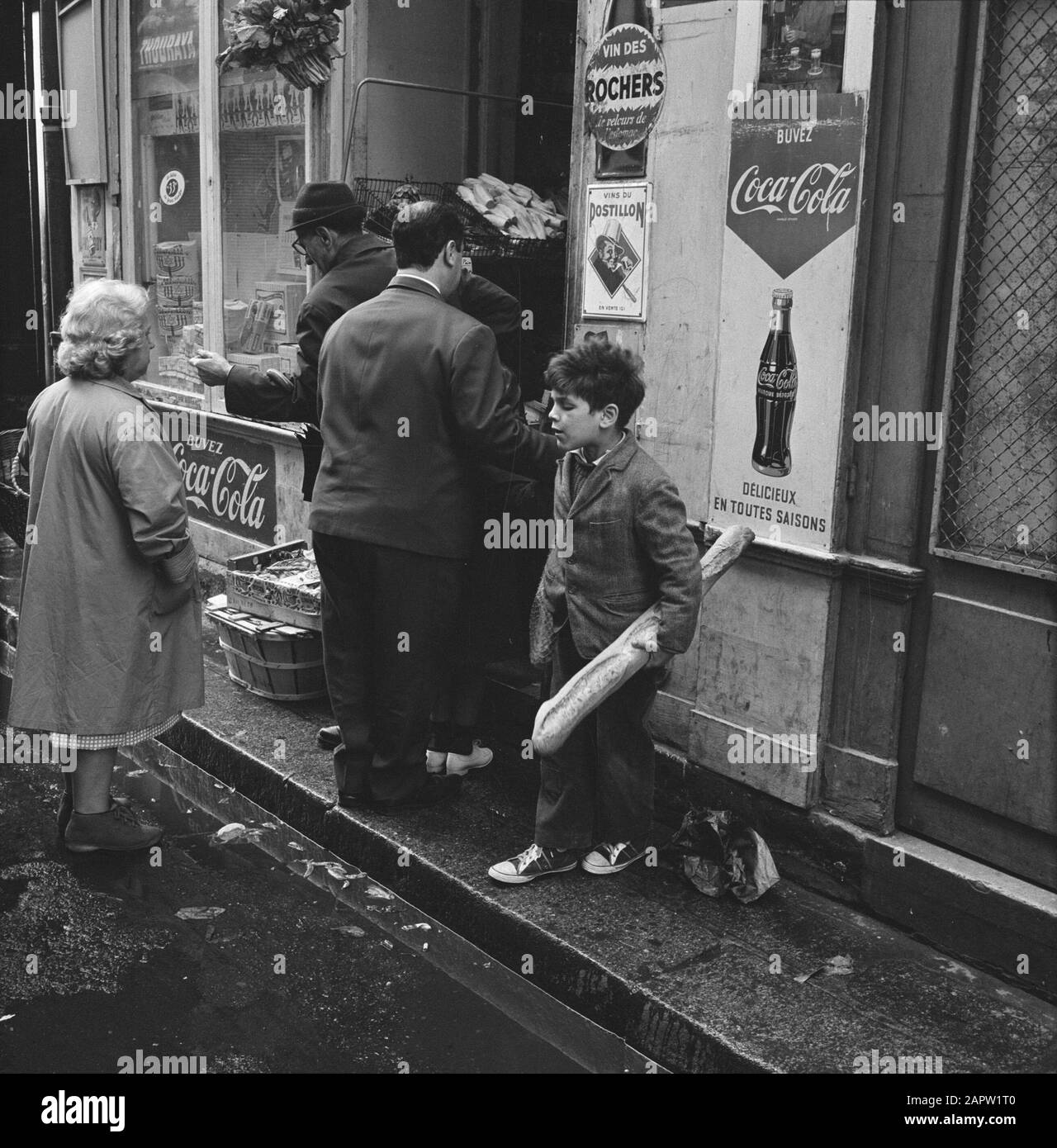 Pariser Bilder [Das Straßenleben von Paris] Junge mit Baguette vor einem Laden Datum: 1965 Ort: Frankreich, Paris Schlüsselwörter: Lebensmittel, Brot, Kinder, Strassenskulpturen, Geschäfte Stockfoto
