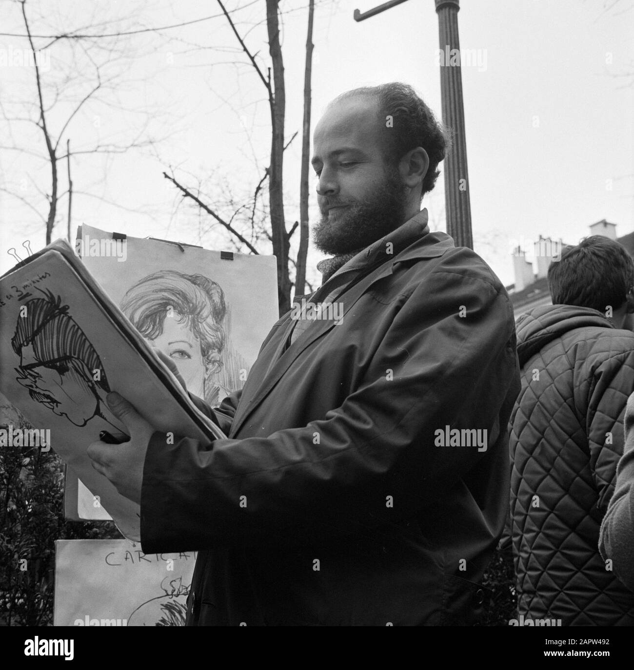 Pariser Bilder [Das Straßenleben von Paris] Karikaturist auf dem Place du Tertre im Herzen von Montmartre Anmerkung: Touristenviertel im 18. Bezirk, traditionell von Malern und anderen Künstlern bevölkert Datum: 1965 Ort: Frankreich, Paris Schlüsselwörter: Cartoons, Straßenkünstler, Straßenplastiken, Zeichner Stockfoto