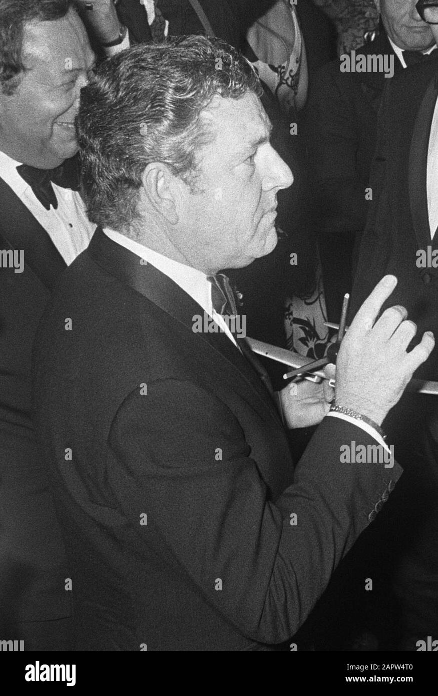 Königin Juliana und Prinz Bernhard nehmen an der niederländischen Galapremiere des Films Battle of Britain im Tuschinski Theater in Amsterdam Teil. Der englische Schauspieler Kenneth More bietet Prinz Bernhard und Königin Juliana ein Modell einer Spitfire an; Stockfoto