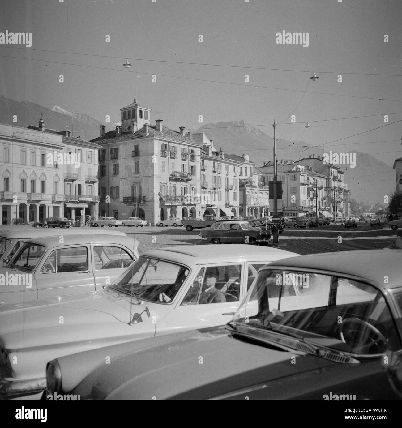 Tour entlang der Schweizer Seite des Lago Maggiore Locarno: Parkplatz auf der Piazza Grande (Hauptplatz) Datum: Oktober 1961 Standort: Locarno, Schweiz Schlüsselwörter: Autos, Gebäude, Hausbesetzer, Städte, Straßenbilder Stockfoto