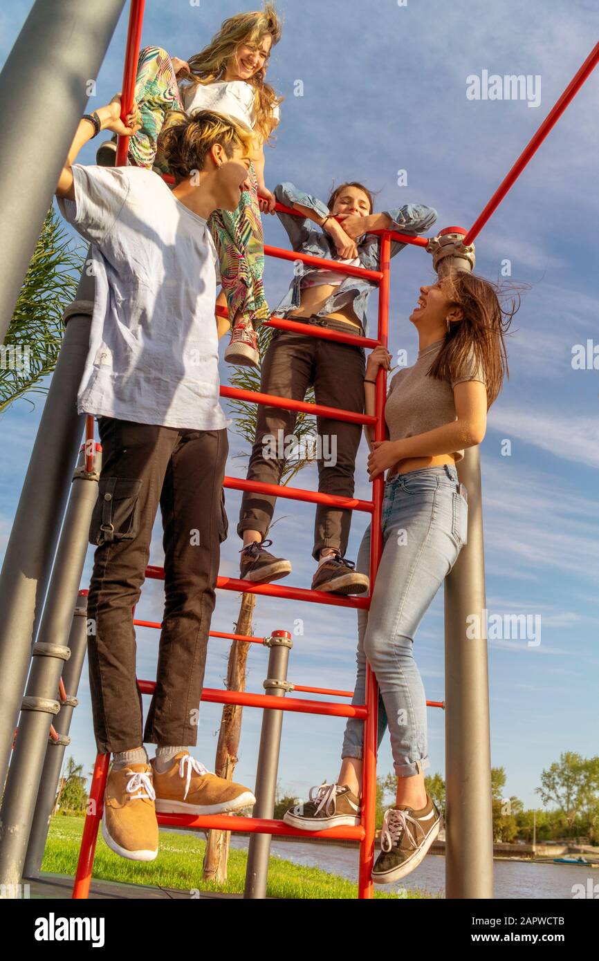 Vier Teenager haben Spaß in einem Outdoor-Fitnessstudio neben einem Fluss Stockfoto