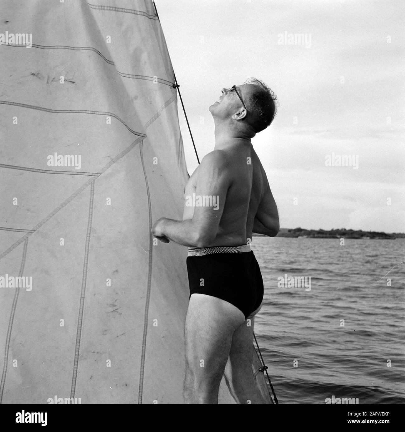 Niederländische Antillen und Suriname zum Zeitpunkt des königlichen Besuchs von Königin Juliana und Prinz Bernhard im Jahre 1955 Mann auf einem segelboot Datum: Oktober 1955 Ort: Curaçao, Niederländische Antillen Schlüsselwörter: Seen, Segelschiffe Stockfoto