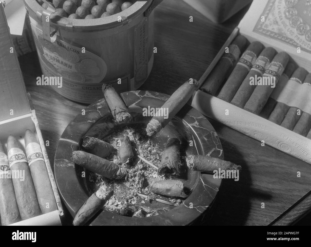 Zigarren- und Tabakgeschäft P.G.C. Hajenius aan het Rokin Amsterdam Marmor-Aschenbecher mit Zigarrenbutten umgeben von mehreren Zigarrenpacks der Marke H. Upmann im Zigarrenhandel Hajenius at Amsterdam Datum: 1935 Ort: Amsterdam, Noord-Holland Schlüsselwörter: Rauchen, Zigarren, Tabakindustrie persönlicher Name: Hajenius, P.G.C. Stockfoto