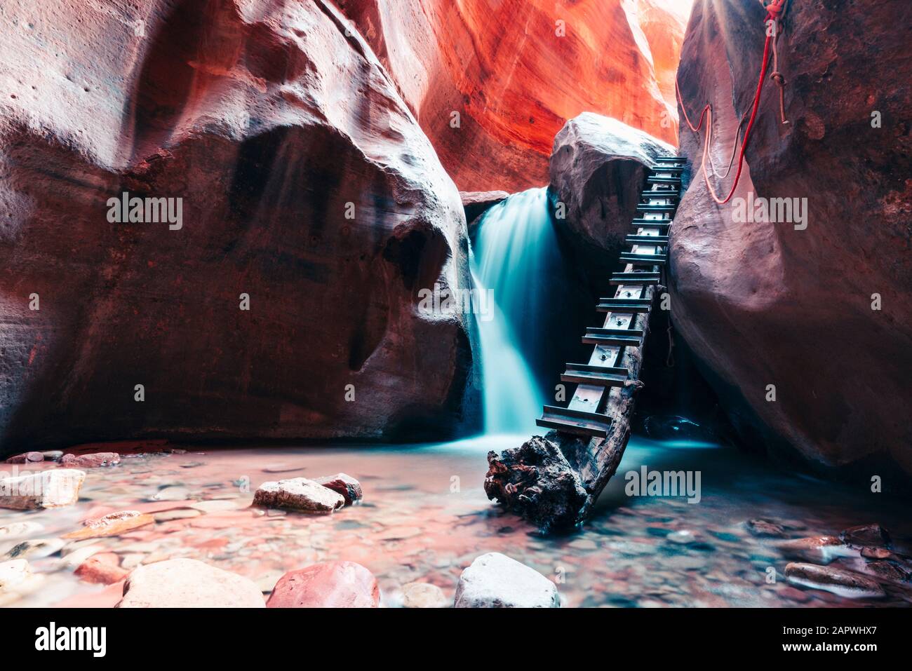 Lange Exposition von Wasserfall über Felsstufe in Slot Canyon fließt Stockfoto