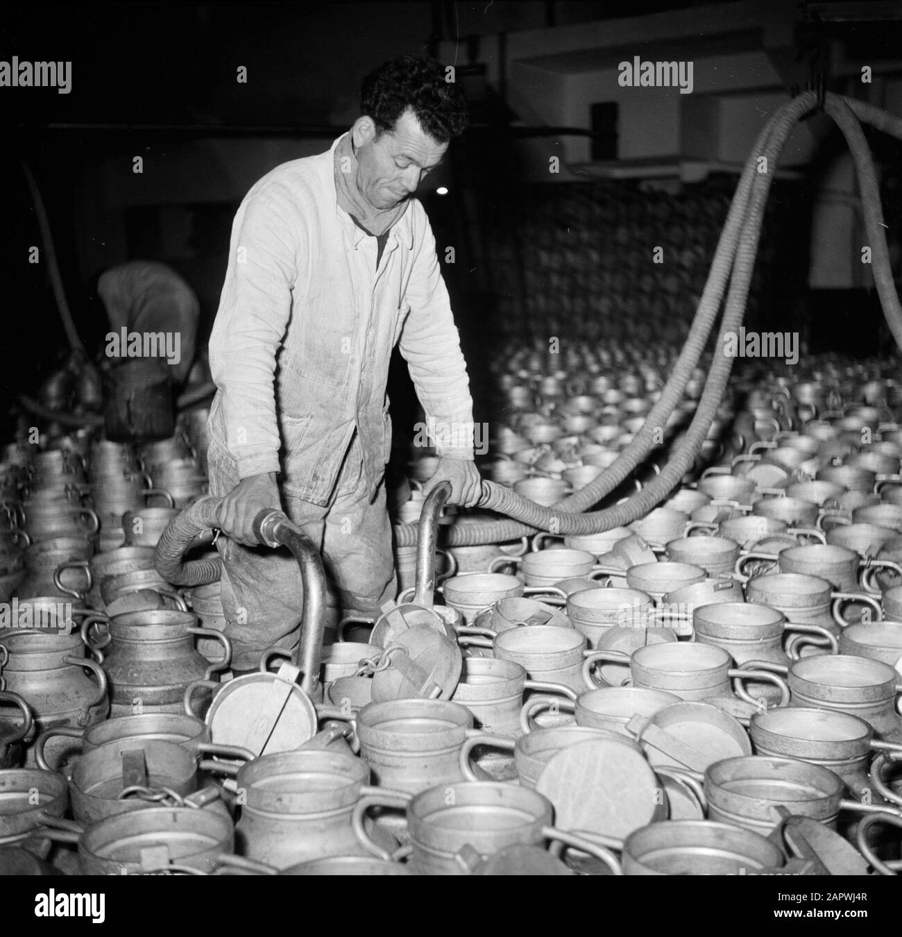 Reportage Paris Milchfabrik: Der Mensch füllt die Milchdosen Datum: 1950 Standort: Frankreich, Paris Schlüsselwörter: Arbeiter, Milch, Milchboxen, Molkereien, Schlangen Stockfoto