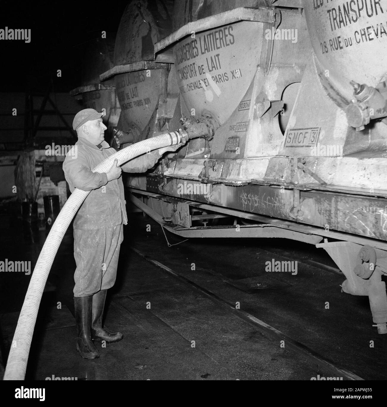 Reportage Pariser Milchfabrik: Der Mensch hilft beim Abpumpen der Milch aus den Waggons Datum: 1950 Standort: Frankreich, Paris Schlüsselwörter: Arbeiter, Milch, Milchdosen, Milchfabriken, Schlangen, Waggons Stockfoto