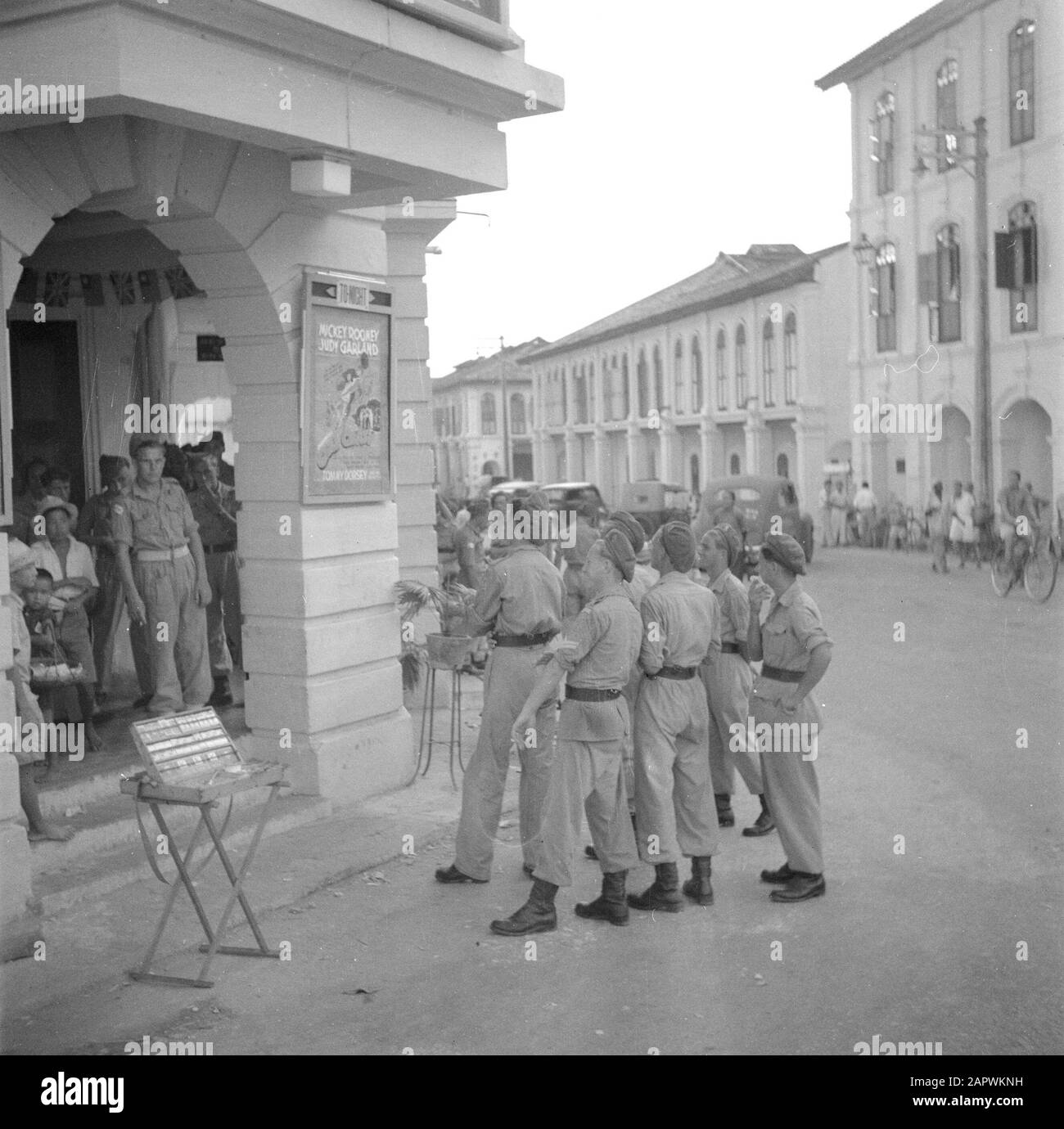 Kriegsfreiwillige in Malakka und Indonesien-Militär in einem Kino in Ipoh. An der Wand ein Plakat des Filmmädchens Crazy von Judy Garland und Mickey Rooney Datum: März 1946 Ort: Ipoh, Malakka, Malaysia Schlüsselwörter: Kinos, Militär, Straßenbilder Stockfoto