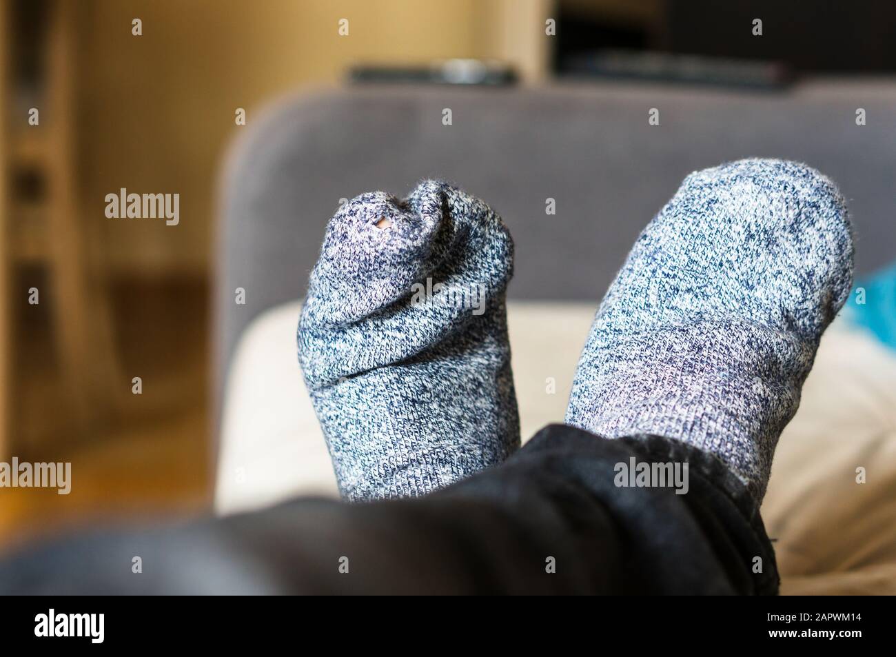 Selektive Fokusaufnahme einer Person, die graue Socken trägt Stockfoto