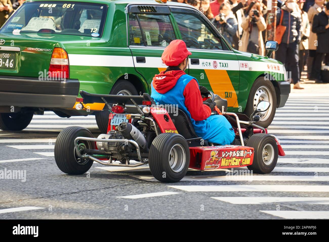 Rückansicht eines japanischen Mannes, der als Mario in einem MariCar (maricar.com)-Wagen oder Auto auf den Straßen von Shibuya unterwegs war. Stockfoto