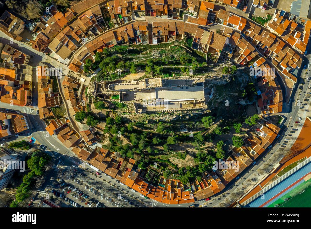 Luftaufnahme der mittelalterlichen Burg Almansa mit Donjon und Innenhof auf einem Felsen, der von dem von einem runden Ring aus roten Dachhäusern umgebenen Plateau auftaucht Stockfoto