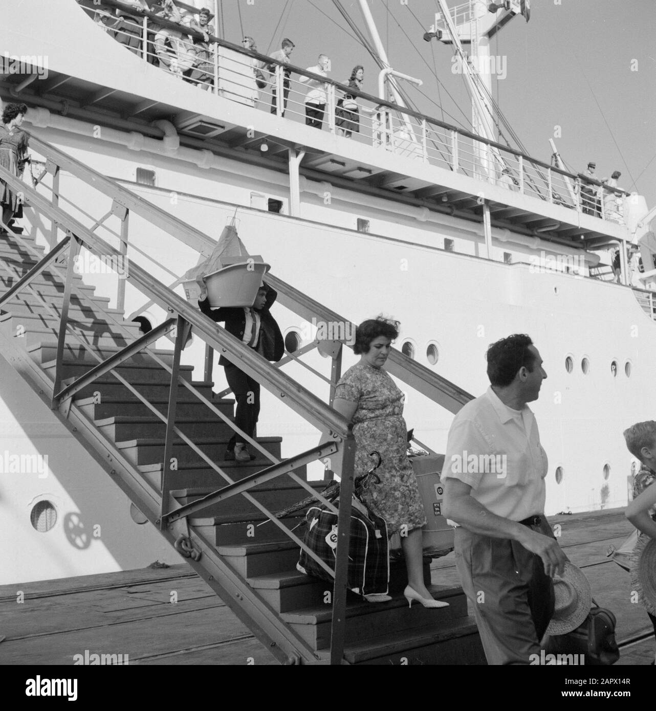 Israel 1964-1965: Haifa, Ankunft von Passagierschiffen Passagiere mit Gepäckspaziergang auf einer mobilen Treppe vom Schiff SS Zion zum Kai Anmerkung: Haifa ist eine Hafenstadt und Badeort in Nordisraelisch, auf dem nordöstlichsten Teil des Karmelgebirges und am Mittelmeer. SS Zion (das abgebildete Schiff) wurde 1956 auf der Deutschen Werft in Hamburg im Rahmen des Rückzahlungssystems (Vereinbarung über Zahlungen aus Deutschland) gebaut und diente zunächst im Transatlantischen Dienst zwischen New York und Haifa, Der Hauptzweck zu dieser Zeit bestand darin, sie wieder in ihre Homela zu bringen Stockfoto