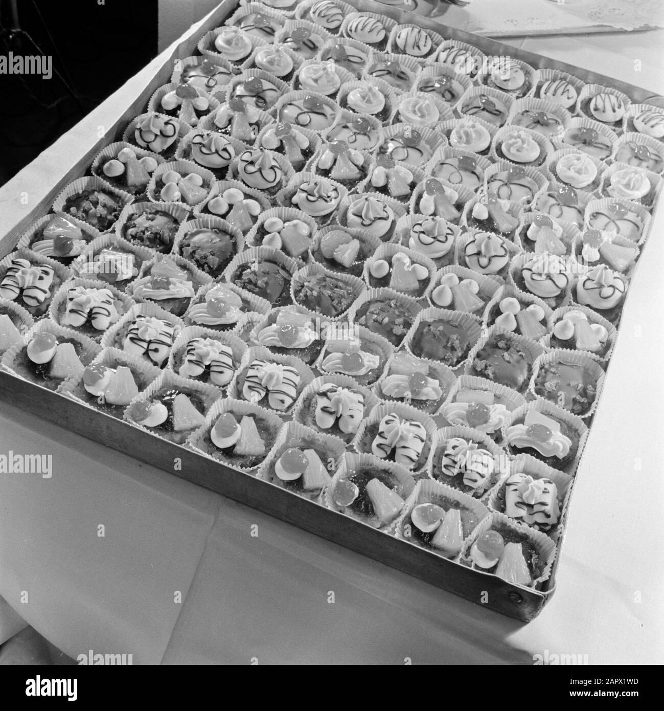 KLM-Mitarbeiter Corporate Identity und Schiphol Petitfours auf einem Teller an Bord eines KLM-Flugzeugs Datum: August 1951 Schlagwörter: Catering-Unternehmen, Gebäck, Mahlzeiten, Flugzeuge Stockfoto