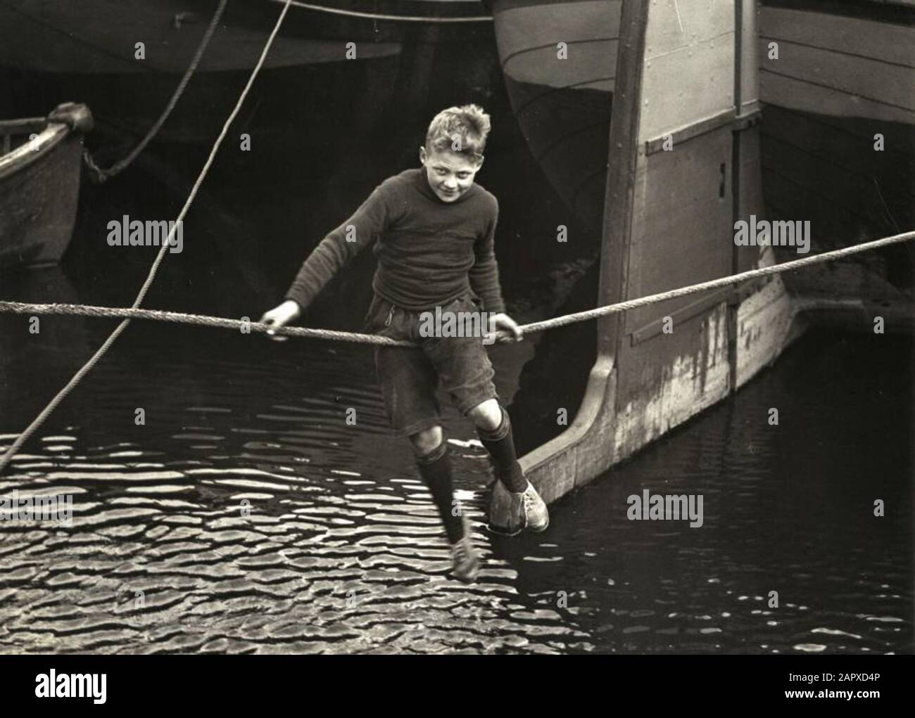 Spar City Foto/Life, SFA022806350 Shipperskindern. Weil die Bildung oft fehlt, nimmt ein Bootsmannkind - aus Langeweile - halsbrecherische Touren im Hafen an, statt zur Schule zu gehen. Foto 1931, Ort unbekannt. Bargees Kinder. Aus Mangel an Schulbildung müssen sich Kinder an Bord eines Barges unterhalten. Niederlande, Standort unbekannt, 1931 Stockfoto