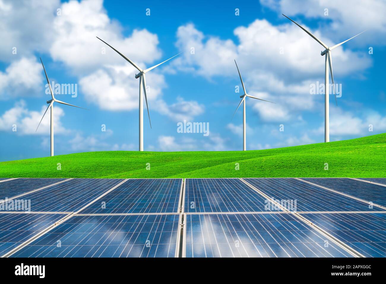 Solarzellen und Windturbinen Farm auf grünem Gras rolling hills gegen den blauen Himmel und weißen Wolken im Sommer. Konzept der erneuerbaren saubere Energie und s Stockfoto