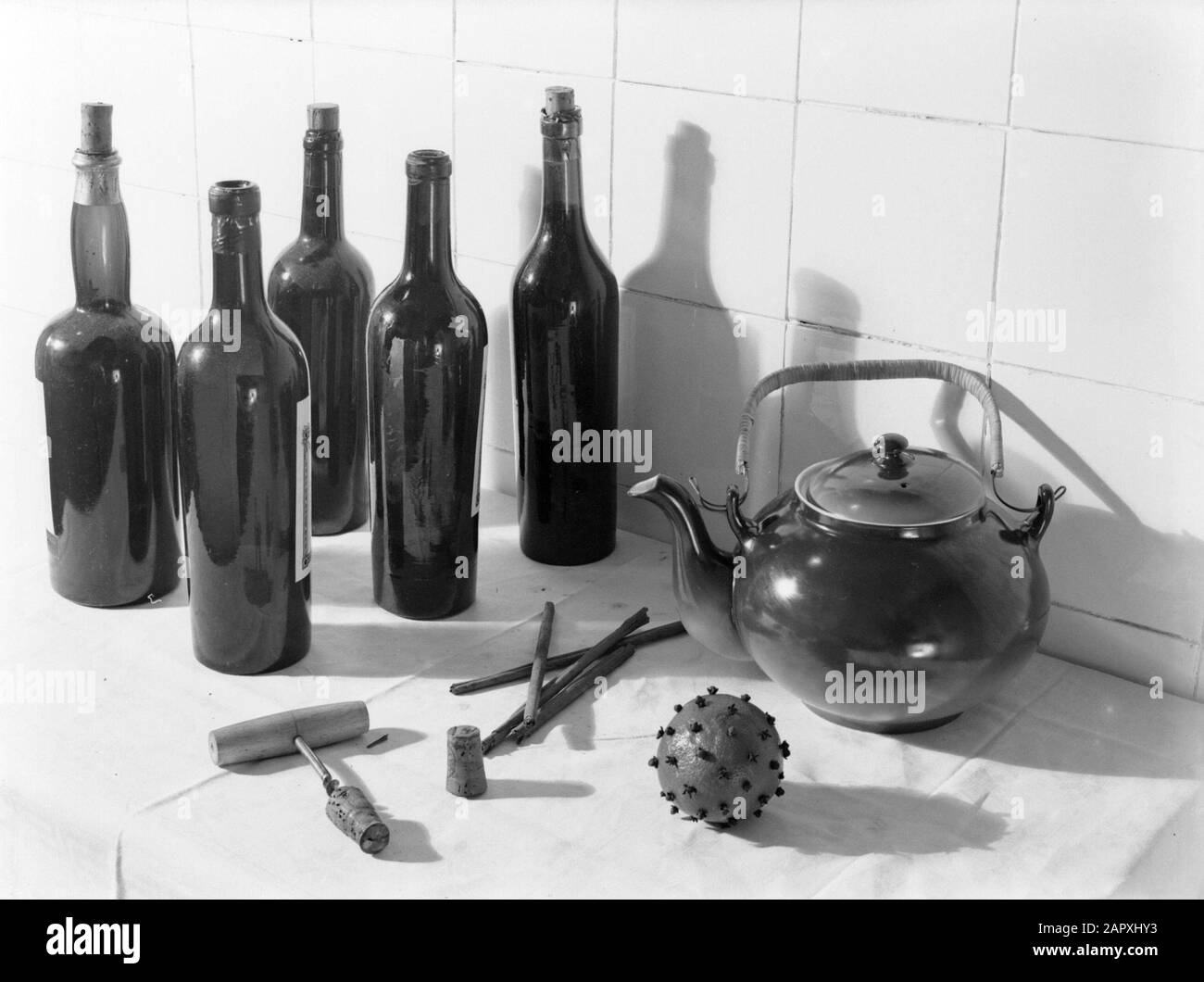 Werbefotografie Stillleben in der Küche von Flaschen, einem Korkenzieher, Zimtrohren, einer Orange mit Nelken und einer Teekanne Anmerkung: Das sind die Zutaten für die Herstellung von Glühwein Datum: 1931 Schlüsselwörter: Flaschen Stockfoto