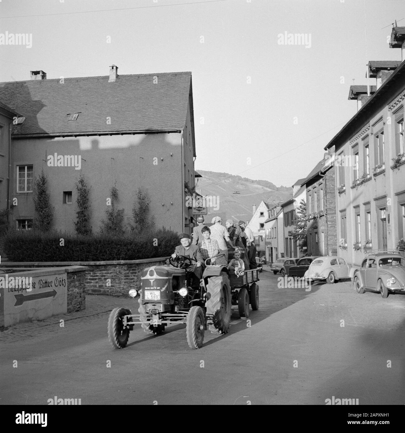 Mosel: Weinbautraktor mit Traubenpflücker und Wanne mit der Traubenernte in den Straßen von Kröv Datum: 1959 Standort: Deutschland, Kröv, Rheinland-Pfalz, Westdeutschland Stichwörter: Trauben, Hügel, Landarbeiter, landwirtschaftliche Werkzeuge, Ernten, Straßenskulpturen, Traktoren, Weinanbau, Wohnungen Stockfoto