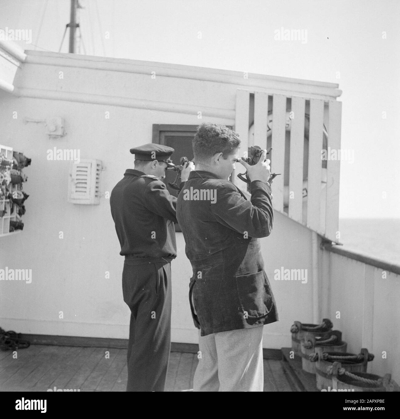 Israel 1948-1949: Seefahrt Zwei Männer an Bord eines Schiffes, das durch eine Sextante Annotation blickt: Möglicherweise machte der Fotograf Willem van de Poll diese Aufnahme an Bord des Schiffes, mit dem er 1948 von Genua nach Haifa unterwegs war Datum: 1948 Ort: Israel Schlagwörter: Kostüme, Navigation, optische Instrumente, Schiffahrt, Seeleute Stockfoto
