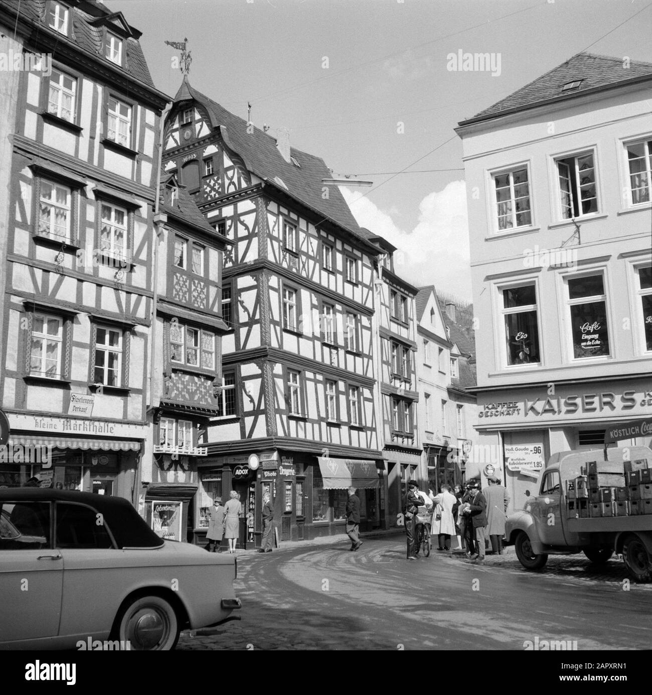 Mosel-Fachwerk am Marktplatz Datum: 1959 Standort: Bernkastel-Kues, Deutschland, Rheinland-Pfalz, Westdeutschland Schlagwörter: Autos, Plätze, Straßenplastiken, Geschäfte, Wohnungen Stockfoto