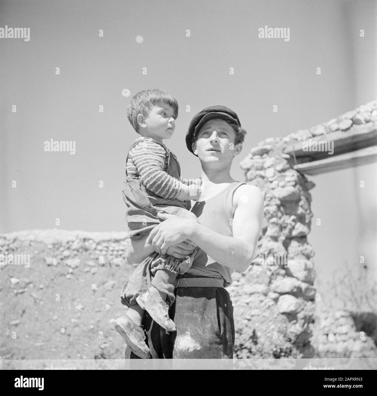 Israel 1948-1949 Vater mit Kind auf Arm an dem Ort, an dem die Familie ihr Haus bauen wird. Dieser Auswanderer trägt den Unterarm die Lagernummer aus dem Konzentrationslager Auschwitz Datum: 1948 Ort: Israel Schlagwörter: Konzentrationslager, Emigranten, Kinder Stockfoto