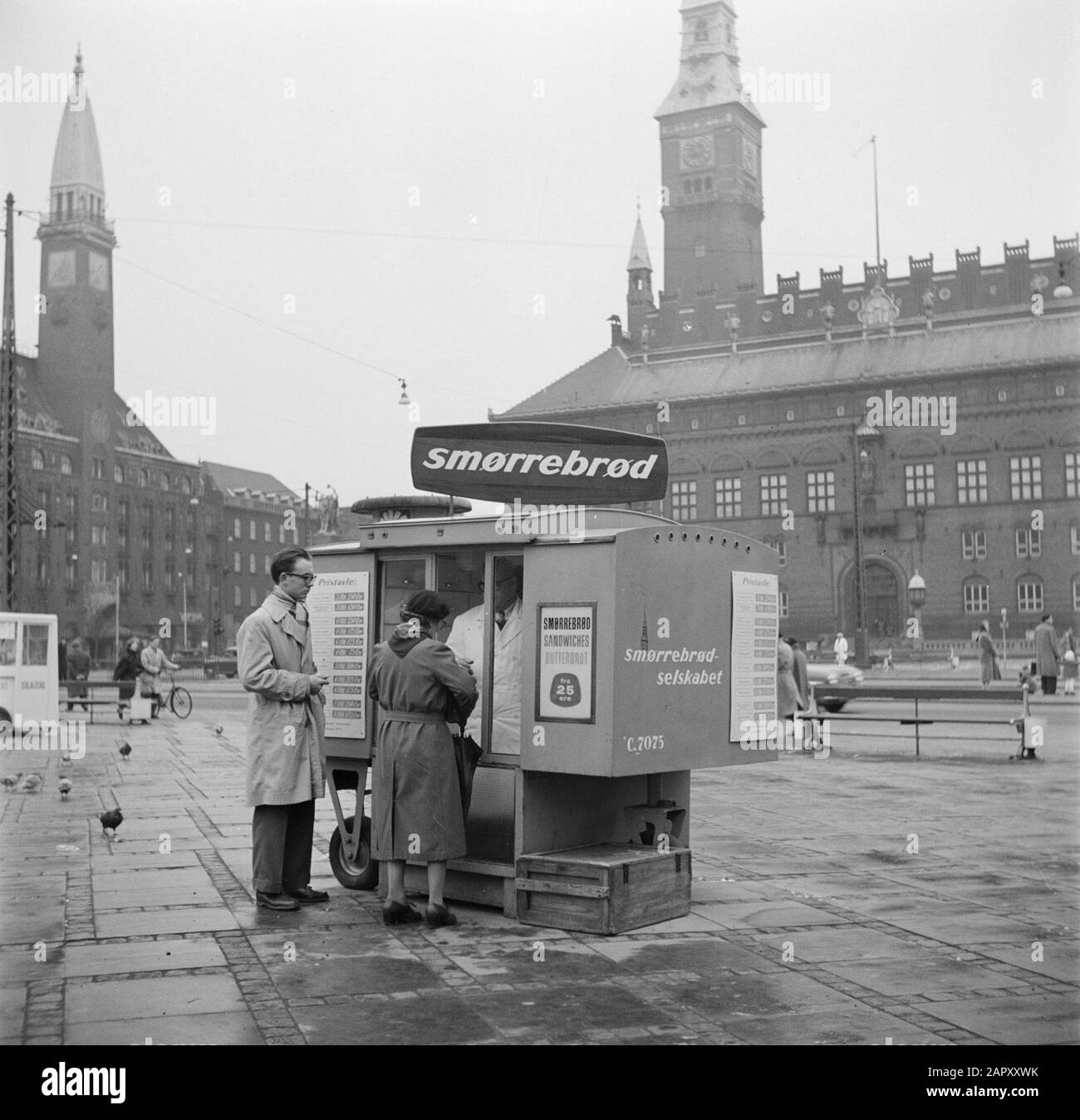 Restaurant Oskar Davidsen Passanten an einem Stand der Firma smørrebrød mit im Hintergrund des Palasthotels und des Rathauses Datum: März 1954 Standort: Dänemark, Kopenhagen Schlüsselwörter: Brot, Brotaufstriche, Rathäuser, Hotels, Kioske, Mahlzeiten, Verkaufsmethoden, Fußgänger Stockfoto