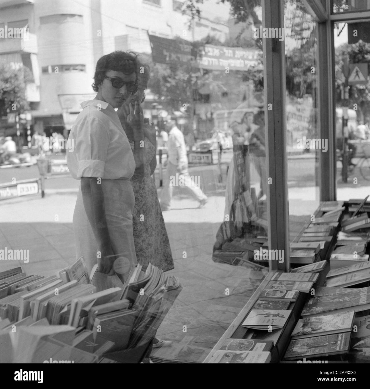 Israel 1964-1965: Tel Aviv, Buchladen Passanten schauen interessiert in das Fenster einer Buchhandlung Annotation: Die Buchhandlung verkauft ausschließlich französischsprachige Bücher. Zu Hause haben die Leute viele Bücher, sie haben ein separates Bücherregal für jedes Kind und eines für die Eltern. Datum: 1964 Standort: Israel, Tel Aviv Schlüsselwörter: Bücher, Buchhandlung, Schaufenster, Straßenbilder, Fußgänger Stockfoto