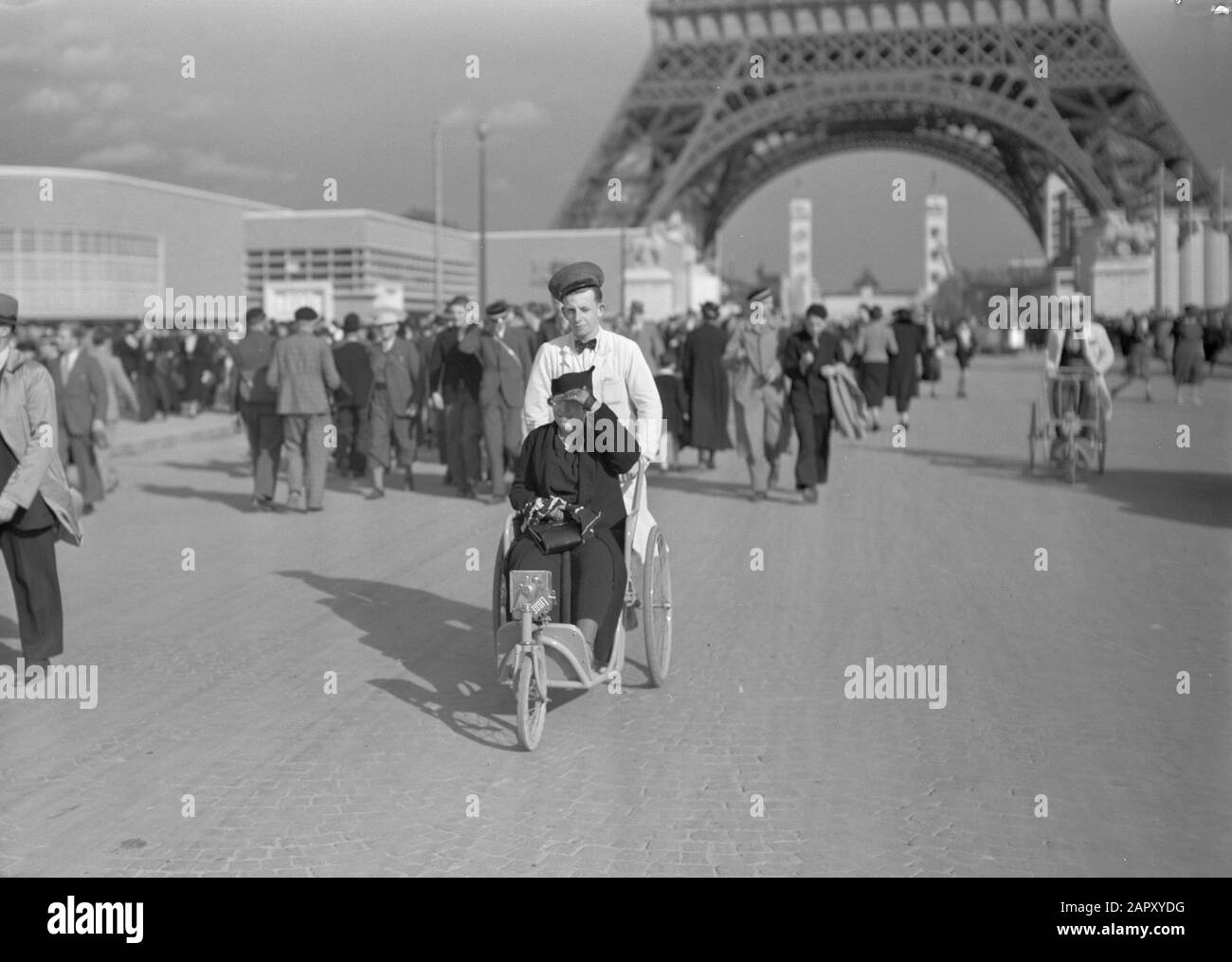Weltausstellung Paris 1937 Frau im Rollstuhl auf dem Messegelände. Im Hintergrund der Eiffelturm Datum: 1937 Ort: Frankreich, Paris Schlagwörter: Besucher, Rollstühle, Ausstellungen persönlicher Name: La Tour eiffel Stockfoto