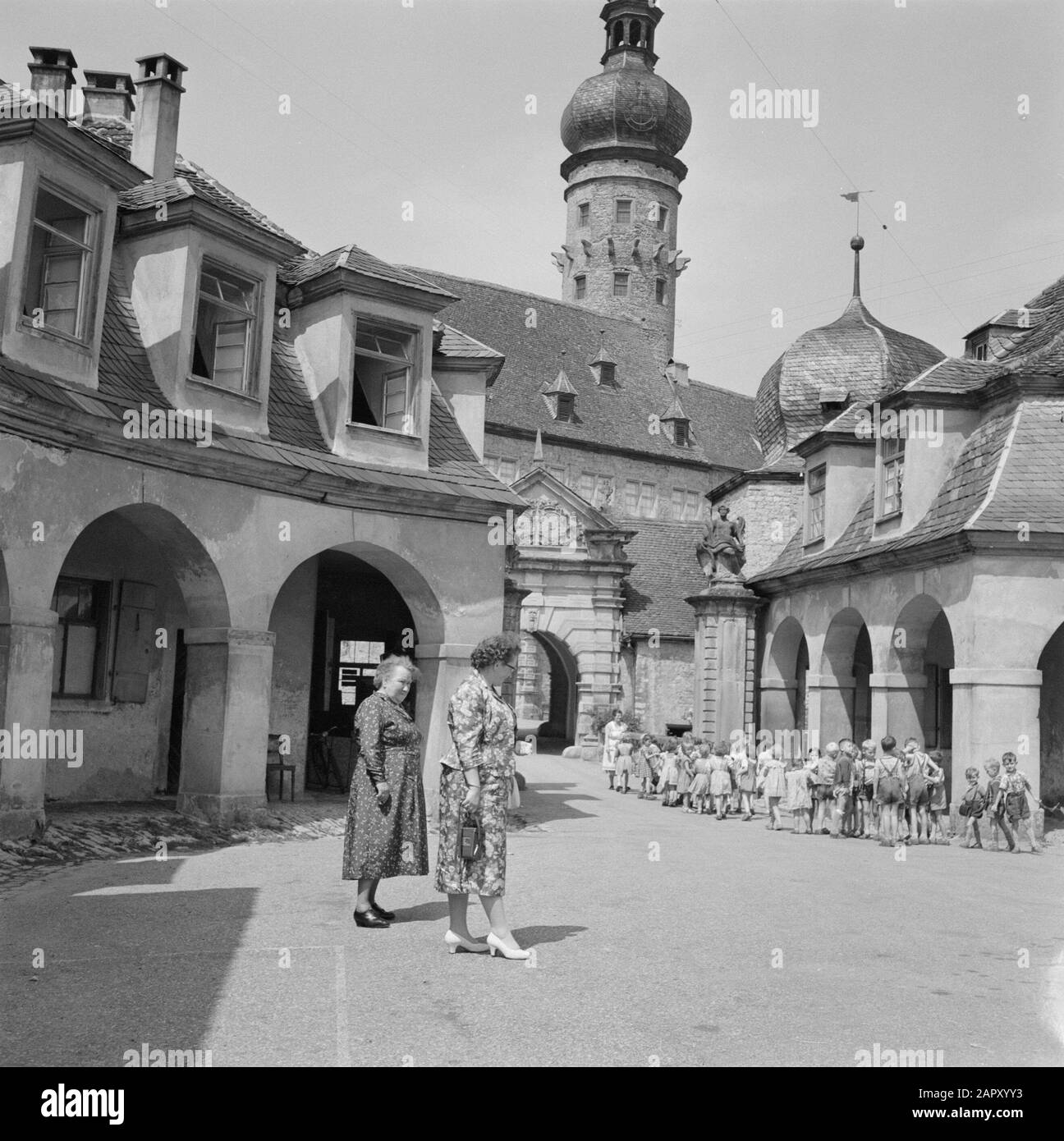Hohenloher Landfrauen beobachten eine Gruppe von Kindern im Burghof Weikersheim Datum: Juli 1959 Standort: Baden-Württemberg, Deutschland, Weikersheim, Westdeutschland Schlagwörter: Burgen, Kinder, Türme Stockfoto